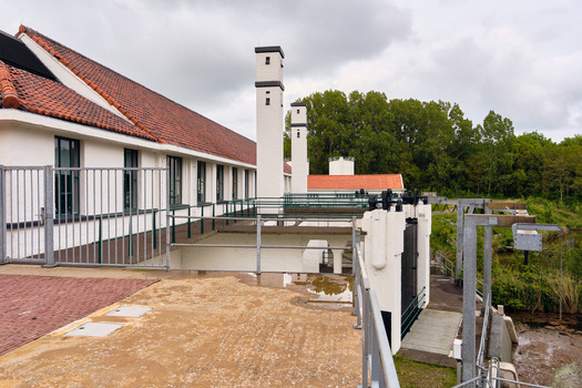 Wieringerwerf Netherlands 17 May 2026 View of the Gemaal Leemans pumping station featuring its white facade red tiled roof and tall chimneys under a cloudy sky.