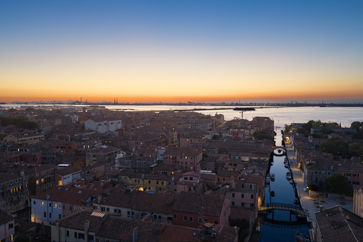 Aerial view of the historic city of Venice with its iconic canals terracotta rooftops and calm waters at sunset in Venice Veneto Italy. Aerial view of the historic city of Venice with its iconic canals terracotta rooftops and calm waters at sunset in Venice Veneto Italy.