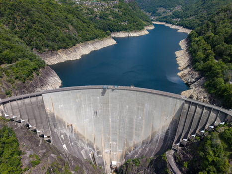 Aerial view of the Verzasca Dam and its deep blue reservoir nestled between steep forested mountains in Gordola Ticino Switzerland. Aerial view of the Verzasca Dam and its deep blue reservoir nestled between steep forested mountains in Gordola Ticino Switzerland.