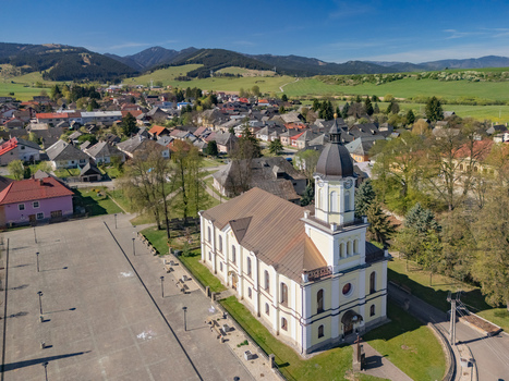 Aerial view of the Church of Saint Matthew and the historic town square surrounded by traditional houses and rolling green hills Partizanska Lupca Zilina Region Slovakia.