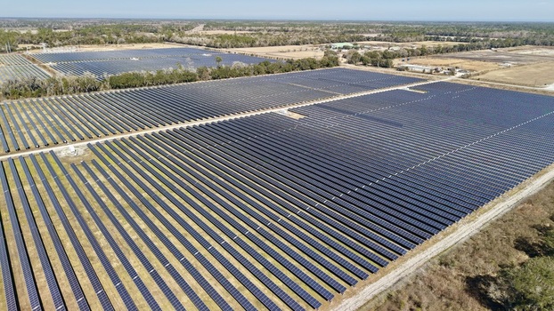 Aerial view of shimmering solar panels stretching across the landscape under a vast sky creating a strong contrast with the dry fields Elkton Florida United States. Aerial view of shimmering solar panels stretching across the landscape under a vast sky creating a strong contrast with the dry fields Elkton Florida United States.