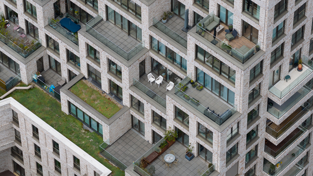 Aerial view of the modern residential building on Cruquiusweg featuring balconies with glass railings outdoor furniture and green roof sections in Amsterdam Noord Holland Netherlands.