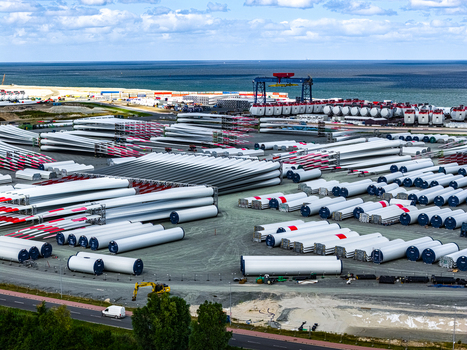 Aerial view of the Siemens Gamesa Renewable Energy facility featuring rows of wind turbine blades stored in an industrial yard near the coast in Cuxhaven Niedersachsen Germany.