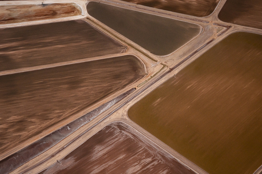 Aerial view of geometric salt evaporation ponds with varying shades of brown and earth tones separated by dirt paths in Australia. Aerial view of geometric salt evaporation ponds with varying shades of brown and earth tones separated by dirt paths in Australia.