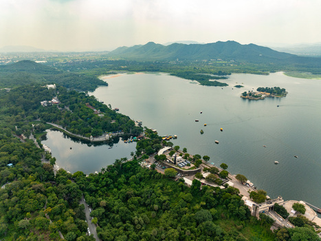 Aerial view of Fateh Sagar Lake surrounded by lush greenery and hills with boats on the water in Udaipur Rajasthan India. Aerial view of Fateh Sagar Lake surrounded by lush greenery and hills with boats on the water in Udaipur Rajasthan India.