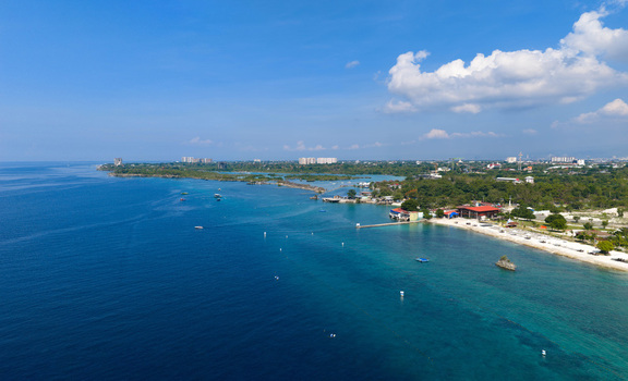 Lapu Lapu Philippines 15 May 2026 Aerial view of the tropical coastline with turquoise waters white sand beaches and coastal resorts under a clear blue sky. Lapu Lapu Philippines 15 May 2026 Aerial view of the tropical coastline with turquoise waters white sand beaches and coastal resorts under a clear blue sky.