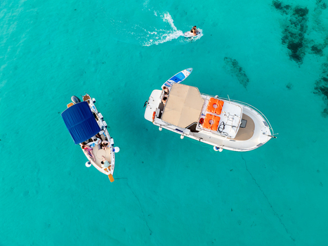 Aerial view of boats floating on the turquoise transparent waters of the Blue Lagoon Comino Malta. Aerial view of boats floating on the turquoise transparent waters of the Blue Lagoon Comino Malta.
