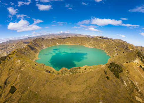 Aerial view of Quilotoa Lake a vibrant turquoise volcanic crater lake surrounded by rugged arid slopes and distant mountains in Quilotoa Cotopaxi Ecuador. Aerial view of Quilotoa Lake a vibrant turquoise volcanic crater lake surrounded by rugged arid slopes and distant mountains in Quilotoa Cotopaxi Ecuador.