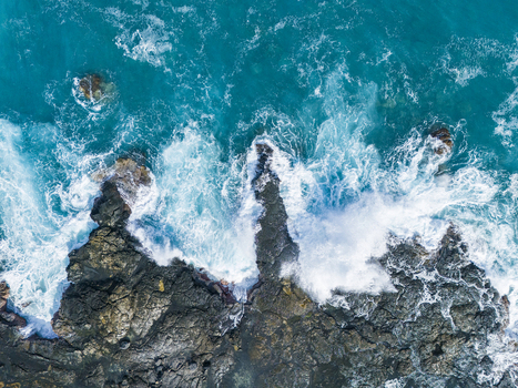 Aerial view of Kalaemamo coastline with turquoise waves crashing against dark volcanic rocks and white sea foam Hawaii County Hawaii United States. Aerial view of Kalaemamo coastline with turquoise waves crashing against dark volcanic rocks and white sea foam Hawaii County Hawaii United States.