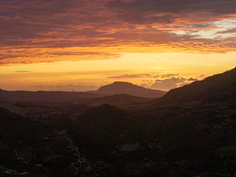 Aerial view of Riserva Naturale Orientata dello Zingaro at sunset with rolling hills and dramatic golden clouds over the landscape in San Vito Lo Capo Sicilia Italy. Aerial view of Riserva Naturale Orientata dello Zingaro at sunset with rolling hills and dramatic golden clouds over the landscape in San Vito Lo Capo Sicilia Italy.