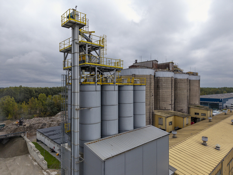 Aerial view of the asphalt plant with tall industrial silos metal structures and a yellow roof in an industrial area in Krakow Lesser Poland Voivode Poland.