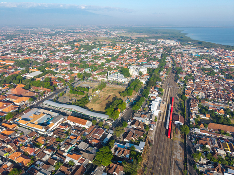 Probolinggo Indonesia 06 August 2026 Aerial view of Probolinggo in East Java showing dense urban rooftops a central square with a mosque and railway tracks near the coastline. Probolinggo Indonesia 06 August 2026 Aerial view of Probolinggo in East Java showing dense urban rooftops a central square with a mosque and railway tracks near the coastline.