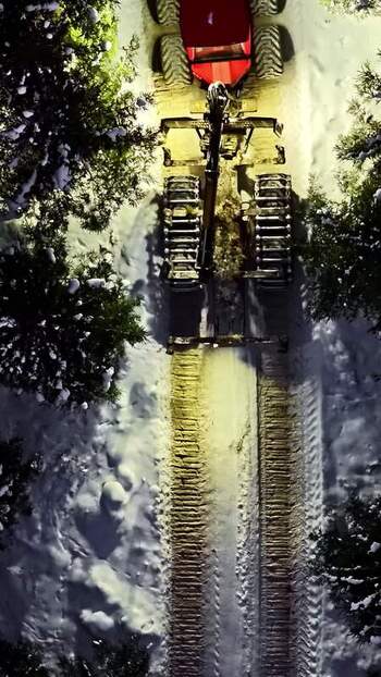Aerial view of forestry machine in snowy forest Latvia.