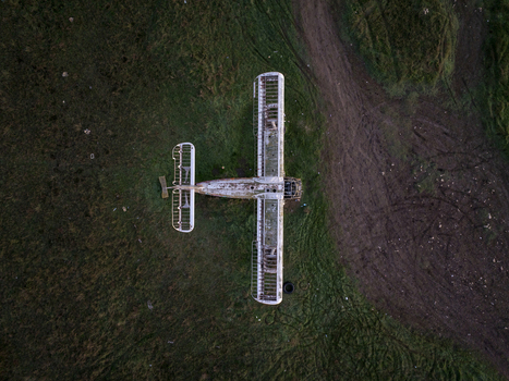 Aerial view of an abandoned skeletal airplane frame resting in a grassy field in Bulgaria. Aerial view of an abandoned skeletal airplane frame resting in a grassy field in Bulgaria.