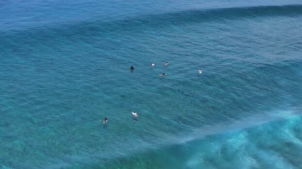 Aerial view of surfers waiting for waves in turquoise water Maldives. Aerial view of surfers waiting for waves in turquoise water Maldives.