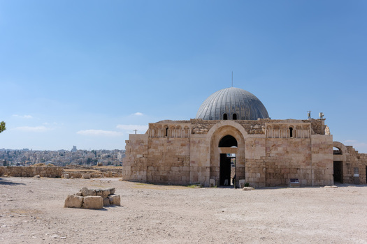 View of the Umayyad Palace with its iconic dome and stone facade set against a clear blue sky in the historic citadel area of Amman Amman Governorate Jordan.