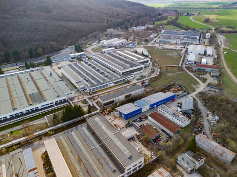 Aerial view of industrial buildings with grey roofs and blue accents nestled among vibrant green fields and dense forests Detva Banskobystricky kraj Slovakia. Aerial view of industrial buildings with grey roofs and blue accents nestled among vibrant green fields and dense forests Detva Banskobystricky kraj Slovakia.