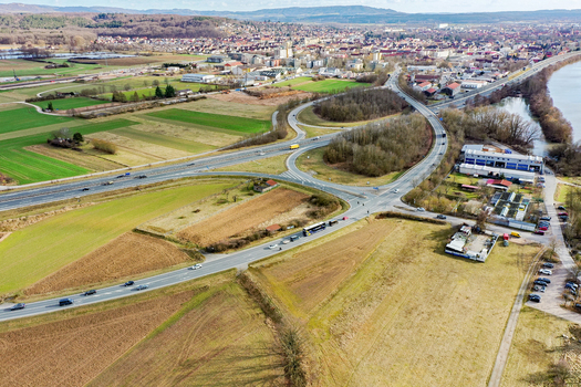 Aerial view of the town featuring a highway junction residential buildings and green fields under a clear sky Buttenheim Bavaria Germany. Aerial view of the town featuring a highway junction residential buildings and green fields under a clear sky Buttenheim Bavaria Germany.