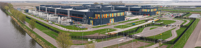 Aerial view of a large modern data center campus with industrial buildings back up energy systems and parking areas situated in the polder landscape of Middenmeer Noord Holland Netherlands.