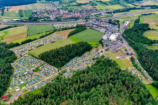 Geiselwind Germany 20 June 2025 Aerial view of the Heroes Festival Geiselwind campsite with numerous tents nestled between lush forests and green fields.