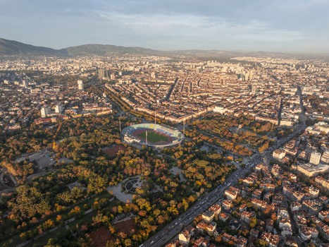 Aerial view of Vasil Levski National Stadium nestled within lush parkland with the dense urban cityscape of Sofia stretching towards the mountains in Sofia Sofia City Province Bulgaria. Aerial view of Vasil Levski National Stadium nestled within lush parkland with the dense urban cityscape of Sofia stretching towards the mountains in Sofia Sofia City Province Bulgaria.