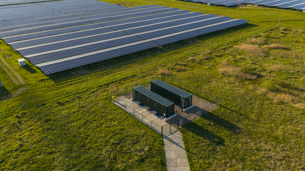 Aerial view of Solar park Delfzijl with rows of photovoltaic panels and green storage containers on a grassy field Farmsum Groningen Netherlands. Aerial view of Solar park Delfzijl with rows of photovoltaic panels and green storage containers on a grassy field Farmsum Groningen Netherlands.