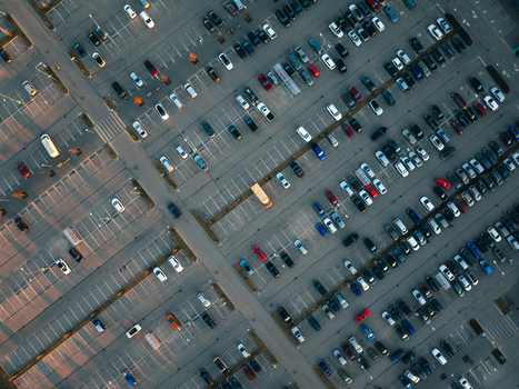 Aerial view of a large parking lot filled with numerous cars during the golden hour sunset in Ulbroka Ropazi Municipality Latvia.