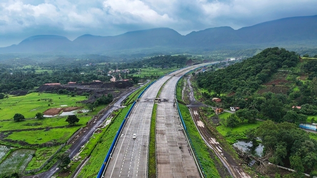 Aerial view of the Delhi Mumbai Expressway cutting through the lush green landscape of Badlapur Maharashtra India. Aerial view of the Delhi Mumbai Expressway cutting through the lush green landscape of Badlapur Maharashtra India.