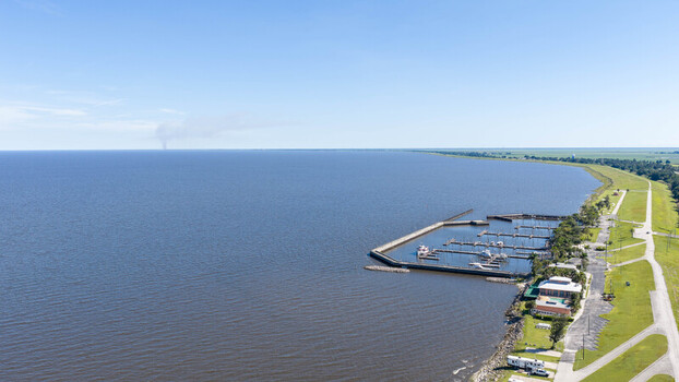 Aerial view of the marina at Lake Okeechobee with boats docked a grassy levee and clear blue sky in Pahokee Florida United States. Aerial view of the marina at Lake Okeechobee with boats docked a grassy levee and clear blue sky in Pahokee Florida United States.