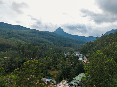 Aerial view of Adam s Peak rising above the lush green valley and the village of Nallathanniya under a cloudy sky Nallathanniya Central Province Sri Lanka. Aerial view of Adam s Peak rising above the lush green valley and the village of Nallathanniya under a cloudy sky Nallathanniya Central Province Sri Lanka.