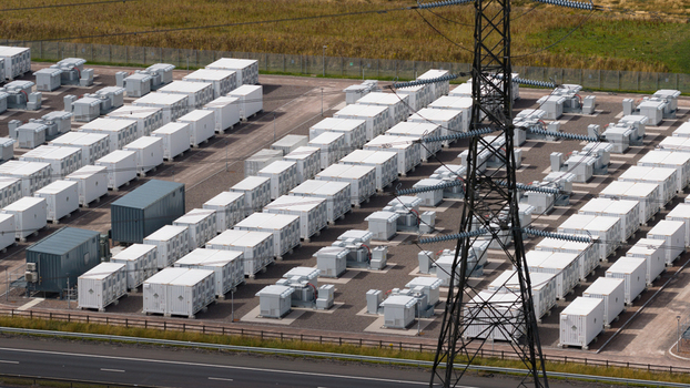 Aerial view of the Coalburn Battery Energy Storage System featuring rows of white energy storage containers and a transmission tower in a gravel facility Coalburn Scotland United Kingdom.