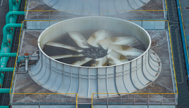 Aerial view of a large industrial cooling fan with rotating blades water pipes and mechanical infrastructure at a heavy manufacturing facility in Brescia Lombardy Italy. Aerial view of a large industrial cooling fan with rotating blades water pipes and mechanical infrastructure at a heavy manufacturing facility in Brescia Lombardy Italy.