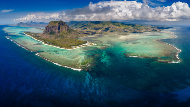 Aerial view of Le Morne Brabant mountain and the underwater waterfall illusion in the turquoise lagoon with coral reefs Moka District Mauritius. Aerial view of Le Morne Brabant mountain and the underwater waterfall illusion in the turquoise lagoon with coral reefs Moka District Mauritius.