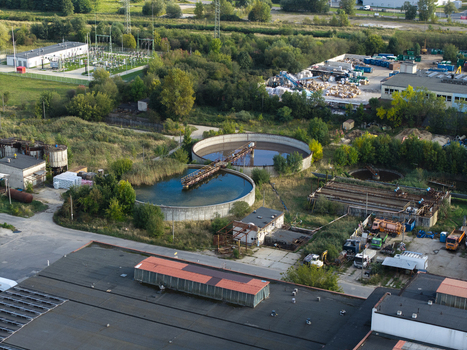 Aerial view of a wastewater treatment plant with circular sedimentation tanks industrial buildings and surrounding greenery in Krakow Lesser Poland Voivode Poland.