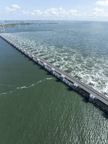 Aerial view of the Eastern Scheldt Storm Surge Barrier a massive flood defense system with turbulent water flowing through sluice gates in Vrouwenpolder Zeeland Netherlands. Aerial view of the Eastern Scheldt Storm Surge Barrier a massive flood defense system with turbulent water flowing through sluice gates in Vrouwenpolder Zeeland Netherlands.