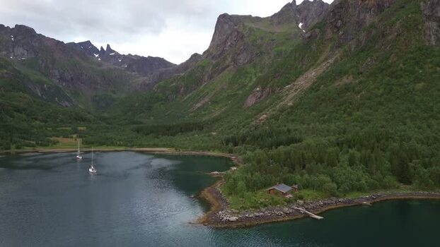 Aerial view of Senja fjord with sailboats and cabin Norway.