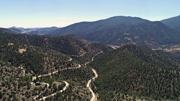 Aerial view of the winding dirt road through the dense pine forests of Virginia Canyon in Idaho Springs Colorado United States. Aerial view of the winding dirt road through the dense pine forests of Virginia Canyon in Idaho Springs Colorado United States.