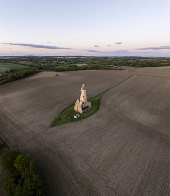 Aerial view of Pusztatorony a historic church ruin standing in the middle of vast agricultural fields during golden hour in Somogyvamos Hungary. Aerial view of Pusztatorony a historic church ruin standing in the middle of vast agricultural fields during golden hour in Somogyvamos Hungary.
