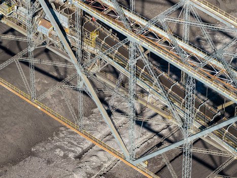 Aerial view of the Tagebau Welzow Sud brown coal open pit mine featuring a massive industrial conveyor system and steel truss structures in Spremberg Brandenburg Germany. Aerial view of the Tagebau Welzow Sud brown coal open pit mine featuring a massive industrial conveyor system and steel truss structures in Spremberg Brandenburg Germany.