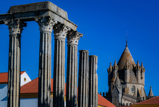 Evora Portugal 09 September 2026 View of the Roman Temple of Evora with ancient columns under a clear blue sky with the historic Evora Cathedral in the background. Evora Portugal 09 September 2026 View of the Roman Temple of Evora with ancient columns under a clear blue sky with the historic Evora Cathedral in the background.