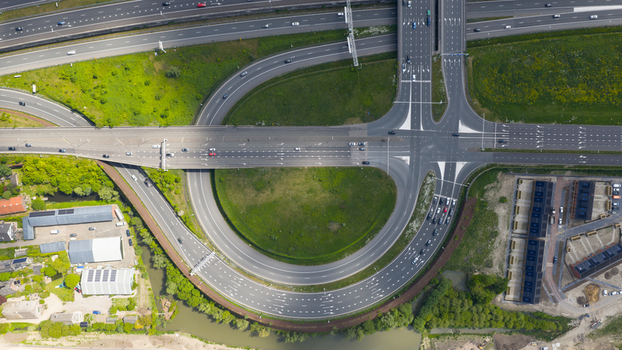 Aerial view of the Stadsbaan Leidsche Rijn highway interchange with cars moving through a circular ramp and multi lane roads surrounded by green fields in Utrecht Utrecht Netherlands. Aerial view of the Stadsbaan Leidsche Rijn highway interchange with cars moving through a circular ramp and multi lane roads surrounded by green fields in Utrecht Utrecht Netherlands.