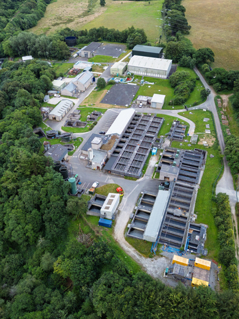 Aerial view of the Restormel water treatment works featuring industrial tanks processing buildings and surrounding woodland in Restormel England United Kingdom.