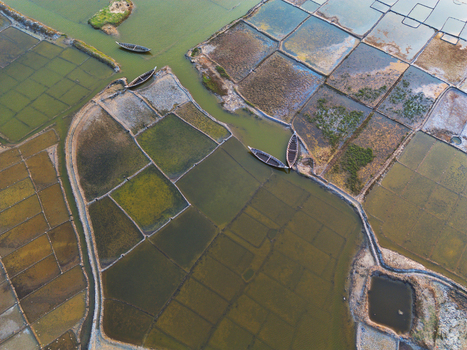 Aerial view of traditional salt pans and aquaculture ponds with small wooden boats in narrow water channels Moheskhali Upazila Chittagong Division Bangladesh. Aerial view of traditional salt pans and aquaculture ponds with small wooden boats in narrow water channels Moheskhali Upazila Chittagong Division Bangladesh.