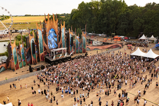 Herzogenaurach Germany 22 July 2022 Aerial view of the main stage at Open Beatz Festival with a large crowd of people a Ferris wheel and surrounding green fields. Herzogenaurach Germany 22 July 2022 Aerial view of the main stage at Open Beatz Festival with a large crowd of people a Ferris wheel and surrounding green fields.