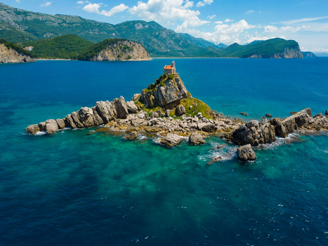Aerial view of St. Nedjelja Church perched on a small rocky islet surrounded by clear turquoise waters of the Adriatic Sea Petrovac Montenegro. Aerial view of St. Nedjelja Church perched on a small rocky islet surrounded by clear turquoise waters of the Adriatic Sea Petrovac Montenegro.