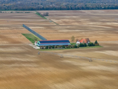 Aerial view of a farm with long building and red roofed house surrounded by vast fields under the open sky Neuf Brisach Grand Est France.