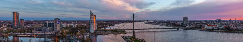 Aerial view of the Riga skyline at sunset featuring modern skyscrapers the Daugava River and the cable stayed Vansu Bridge in Riga Latvia.