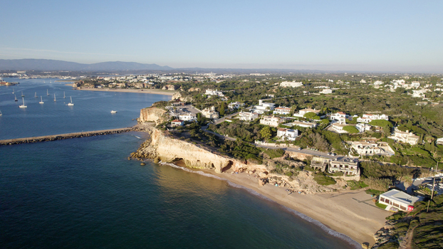 Aerial view of the coastal town of Ferragudo with its sandy beach rocky cliffs and residential villas overlooking the Atlantic Ocean Ferragudo Faro District Portugal.
