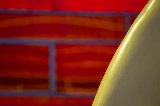 View of a yellow object contrasts against a vibrant red brick wall with blurred blue grout creating a striking abstract composition La Defense Netherlands. View of a yellow object contrasts against a vibrant red brick wall with blurred blue grout creating a striking abstract composition La Defense Netherlands.