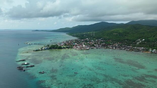 Aerial view of coastal town and green hills Indonesia. Aerial view of coastal town and green hills Indonesia.